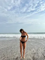 Bombacha de bikini negra tipo vedetina, con laterales fruncidos y finos.