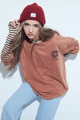 Remera de corte oversize color marrón con efecto gastado, manga corta y estampa gráfica retro en el frente.