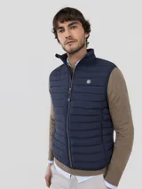 Chaleco acolchado para hombre de nylon reciclado, color verde militar, con cierre de cremallera frontal, bolsillos laterales y cuello alto.