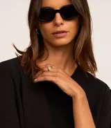 Blusa negra de crepé con cuello redondo y mangas cortas decoradas con lazos aplicados.