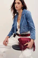 Saco corto de denim azul con solapas y bolsillos ribeteados, confeccionado en mezcla de algodón y poliéster.
