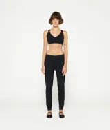 Top deportivo blanco de algodón orgánico con tirantes cruzados en la espalda y logo de minirayas.