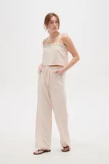 Musculosa de viscosa color natural, con breteles finos ajustables con lazos, cuello cuadrado y detalle bordado geométrico en el escote.