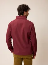Campera softshell color gris, con cierre frontal completo, cuello alto y bolsillos laterales y en el pecho con cierre. Cuenta con logo bordado en el pecho y ajuste en los puños.