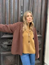Saco tejido tipo campera color marrón chocolate, con cierre frontal completo, cuello redondo y puños acanalados. Presenta un diseño de corte recto y holgado.