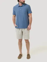Chomba azul melange de manga corta con cuello polo, tapeta con tres botones y un bolsillo aplicado en el pecho.