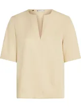 Blusa color crema de Tommy Hilfiger, de corte regular, con cuello en V y mangas cortas.