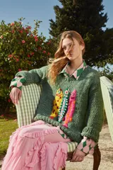 Sweater de lana verde tejido y bordado a mano con cuello a la base y puños. Presenta bordados de peces de colores en el frente. De calce holgado.