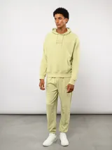 Pantalón jogger de felpa sin frisa, color gris claro melange, con logo bordado de Umbro en azul oscuro en el muslo izquierdo y puños elásticos en los tobillos.