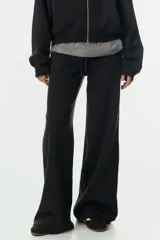 Pantalón deportivo de felpa en color negro, con diseño de pierna levemente acampanada. Presenta cintura elástica con cordón de ajuste y un interior cepillado suave.