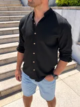 Camisa de lino negra de manga larga, con cuello mao y cierre frontal de botones en contraste.