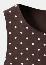 Mono enterito de lino color marrón con estampado de lunares blancos, cuello redondo, sin mangas, perneras rectas y cinturón integrado con hebilla a tono.