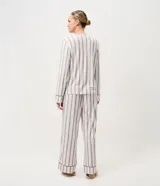 Pijama largo de 2 piezas, compuesto por una blusa de manga larga con escote en V y un pantalón de corte recto, confeccionados en tejido efecto piel de durazno con estampa de rayas y ribetes contrastantes en cuello, puños y ruedo.