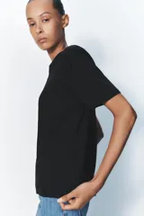 Camiseta de algodón color negro, con cuello redondo, manga corta y corte regular fit.