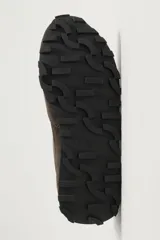Zapatilla deportiva de hombre confeccionada en piel con acabado de serraje, diseño de paneles y suela dentada.