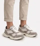 Championes deportivos para hombre de la marca Renner, confeccionados en material sintético con detalles tipo gamuza en tonos gris, blanco y beige. Poseen diseño con recortes superpuestos, cierre de cordones y entresuela volumosa.