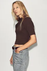 Jersey de punto marrón oscuro, cuello redondo y manga corta, con diseño de punto acanalado y detalles en punto diamante en el torso.