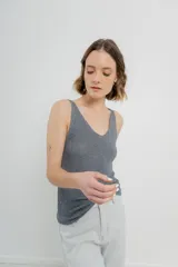 Musculosa tejida color amarillo pálido, con escote en V delantero y trasero.