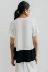 Remera blanca con corte horizontal y parte inferior negra.