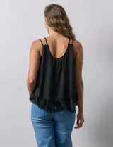 Blusa negra de gasa con breteles finos trenzados, escote redondo y capas superpuestas de encaje y gasa en el frente.