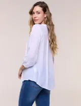 Blusa de silueta suelta color azul, con escote en V y cuello mao. Cuenta con abotonadura frontal, alforzas verticales en el pecho y mangas tres cuartos con puños elastizados.