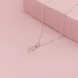 Dije de plata 925 con diseño de corazón dividido en dos mitades, cada una con su propia argolla de sujeción.