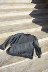 Buzo negro de algodón con cuello redondo y logo bordado en el pecho.