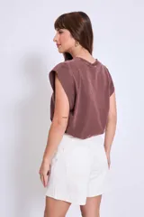 Bermuda de jean color crudo, tiro alto, corte recto y largo a la rodilla.