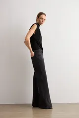 Jean estilo wide leg de tiro medio, color negro, confeccionado en denim con apliques de brillos en los laterales.