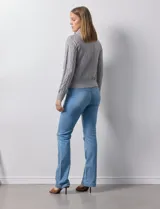 Cardigan de tejido jacquard color gris con diseño geométrico en relieve. Presenta cuello con solapa, cierre frontal completo y bolsillos decorativos en el pecho.