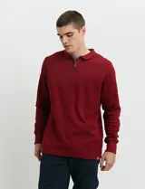 Remera de punto canalé francés con cuello polo, manga larga y cierre frontal de metal con tirador personalizado.