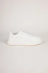 Zapatillas blancas de símil cuero con recortes en distintas texturas y plataforma de 4cm de alto.