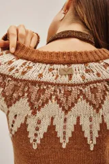 Cardigan de punto color tostado con diseño jacquard en tonos crema y marrón, decorado con lentejuelas. Presenta cuello redondo, cierre frontal con botones oscuros y puños acanalados.