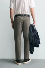 Pantalón de corte carrot fit confeccionado en tejido de algodón con estructura diagonal y efecto lavado. Presenta bolsillos frontales con bolsillo cerillero, bolsillos traseros de plastrón y cierre frontal con cremallera y botón.