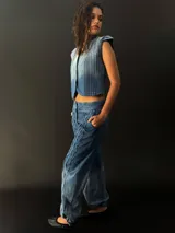 Chaleco de jean con cuello y pequeñas mangas, con alforzas texturizadas en los laterales.