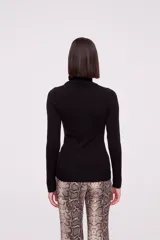 Polera de tejido de punto color blanco, con cuello redondo y manga larga.