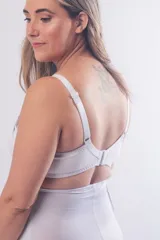 Soutien maternal sin aro, color blanco, diseñado con doble clip en los breteles para facilitar la lactancia y el uso de extractor. Presenta un escote alto, breteles elásticos regulables y cierre de broches en la espalda.