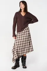 Sweater de tejido de punto fino en color beige, con silueta holgada, cuello en V y diseño de textura ramificada en relieve.