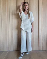 Pantalón de punto calado color crudo, de corte palazzo y cintura elástica.