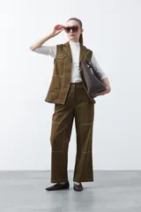 Pantalón de corte recto y tiro medio, confeccionado en algodón con elastano. Presenta costuras a contratono en color blanco que resaltan los recortes delanteros y el diseño de la prenda, aportando un estilo utilitario.