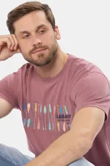 Remera de manga corta color ladrillo con cuello redondo y estampado frontal con diseño de remos y texto "Legacy Established 1972".