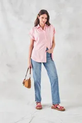 Blusa de viscosa con estampado de rayas verticales en color blanco y rosado, cuello camisero, cierre frontal con botones y mangas cortas con dobladillo.