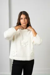 Buzo de punto color blanco, de corte oversize y cuello redondo, decorado con flores aplicadas en relieve con centros bordados en perlas.