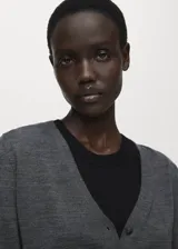 Cardigan de punto fino con cuello en pico y cierre frontal de botones. Presenta un diseño recto de manga larga, confeccionado en lana.