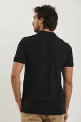 Polo de piqué color rojo, manga corta, con cuello y tapeta de botones al tono.