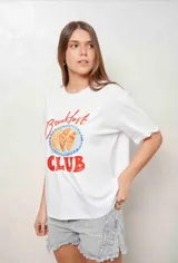 Remera blanca con diseño estampado de medialunas y texto 'Breakfast Club', con detalles en piedritas bordadas y mangas cortas.