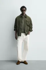 Cazadora relaxed fit de algodón color verde militar, con efecto lavado, cuello solapa de pana a tono y manga larga. Cuenta con bolsillos de plastrón delanteros y cierre frontal de botonadura.
