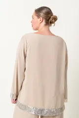 Blusa italiana de gasa color fucsia, con escote redondo y mangas largas acampanadas. Presenta apliques de lentejuelas al tono en el ruedo y los puños.