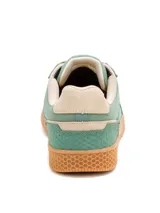 Championes Caterpillar modelo Pause Retro, de diseño urbano con combinación de lona y gamuza en tonos verde y beige. Presenta suela de goma color caramelo con textura hexagonal y logo de la marca en el lateral y la lengüeta.