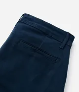 Pantalón masculino de corte skinny confeccionado en sarga de algodón con elastano. Presenta cierre frontal con botón y cremallera, cintura con trabillas y bolsillos laterales y traseros.